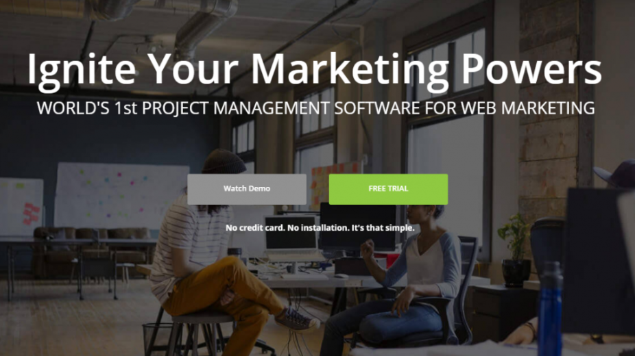 A diverse team collaborates in a modern office. The text overlay reads, "Ignite Your Marketing Powers. WORLD's 1st PROJECT MANAGEMENT SOFTWARE FOR WEB MARKETING AND SEO." There are two buttons for "Watch Demo" and "FREE TRIAL," with a note about no credit card being required.